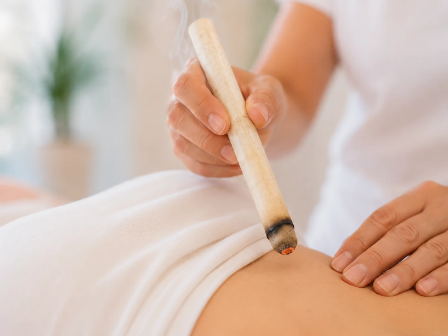 Der Abstand zur Haut wird beim Moxen konstant gehalten im Akupunktur Zentrum Wohlen